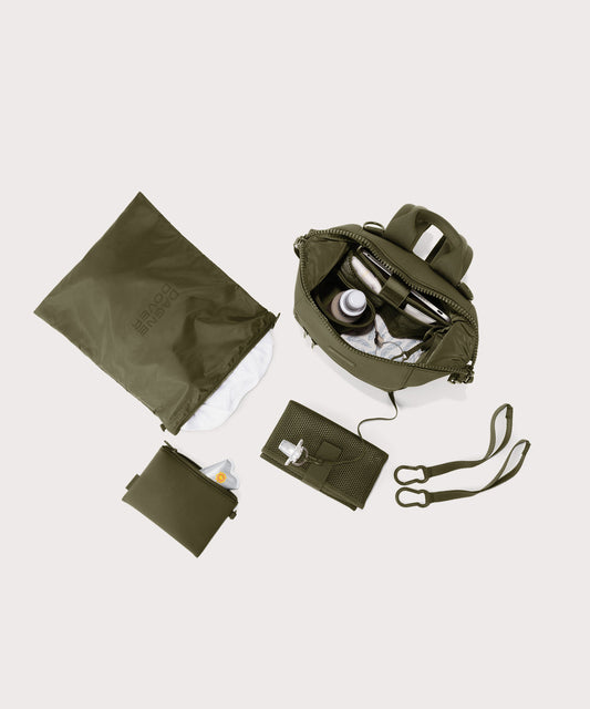 Dagne Dover small Indi Diaper Backpack in dark moss showing it's water resistant bag, interior pockets, and changing mat.