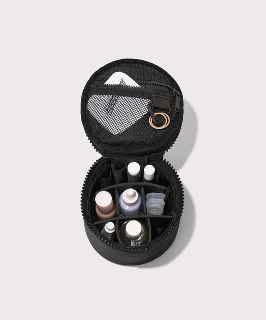 Dagne Dover small Mila Toiletry Pouch in black unzipped filled with toiletry products.