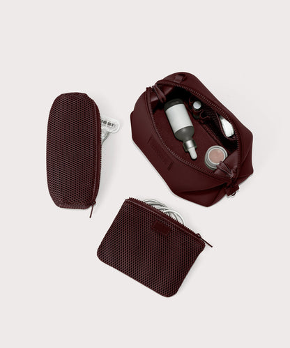 Dagne Dover Large Hunter Toiletry Bag in a deep brown with purple undertones unzipped and seen from above with the removable air mesh pouch alongside it.