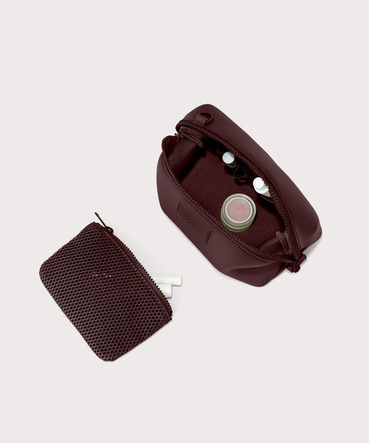 Dagne Dover Small Hunter Toiletry Bag in a deep brown with purple undertones unzipped and seen from above with the removable air mesh pouch alongside it.