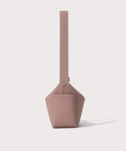 Shoulder bag in a pink seen from the side view showing phone pocket.