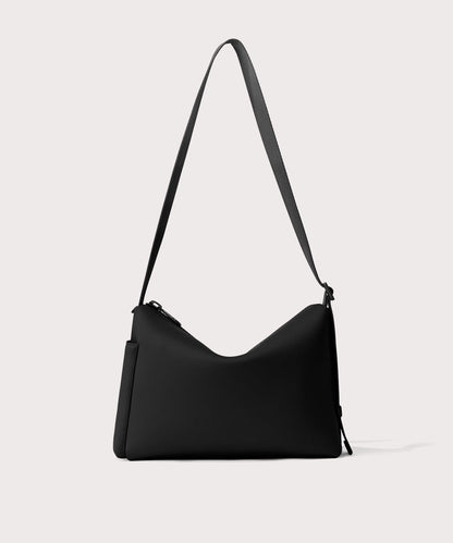 Shoulder bag in a black seen from the back view showing phone pocket.