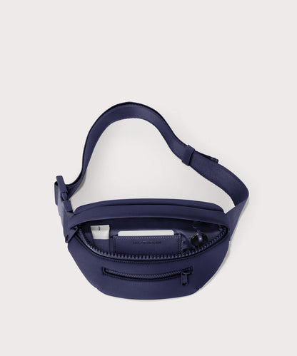 Dagne Dover Ace Fanny Pack in dark blue unzipped, exposing the interior pockets