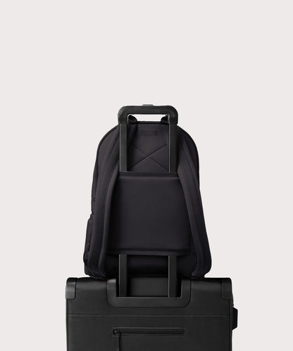 Dagne Dover large Dakota Neoprene Backpack in black strapped to luggage with the neoprene luggage-handle sleeve.