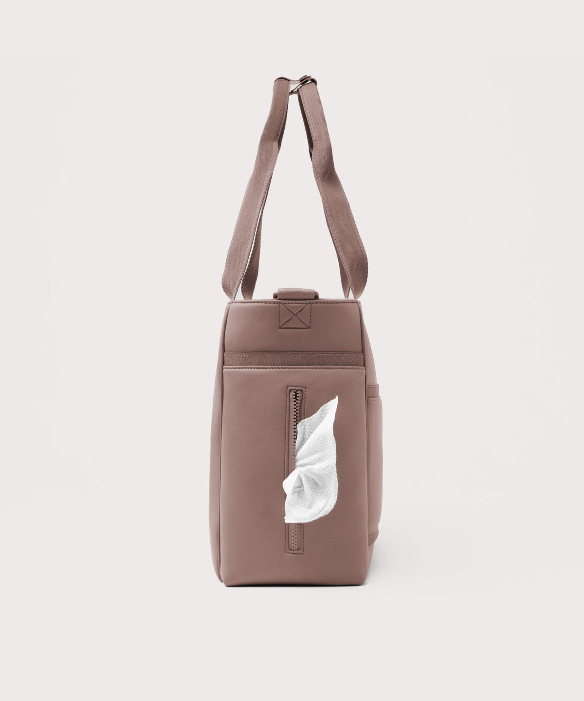 Dagne Dover large Wade Diaper Tote in pink seen from the side, with a wet wipe poking out of the slip pocket.