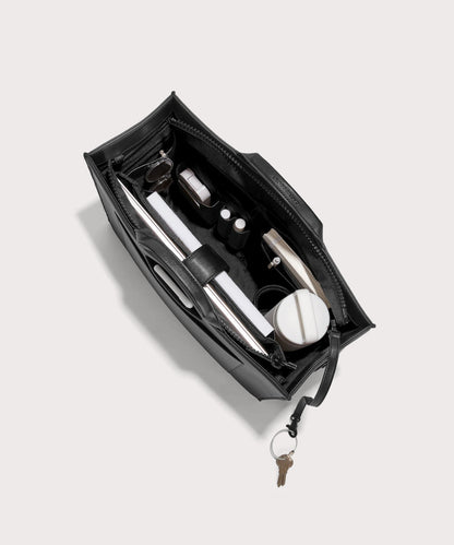 hover - Dagne Dover large vegan Daily Tote in black from above, revealing the interior zipper, interior slip pockets, and padded laptop sleeve.