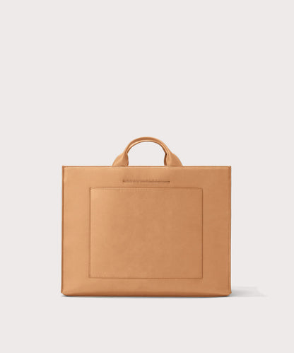 Dagne Dover large vegan Daily Tote in brown revealing the exterior phone pocket and exterior luggage sleeve.