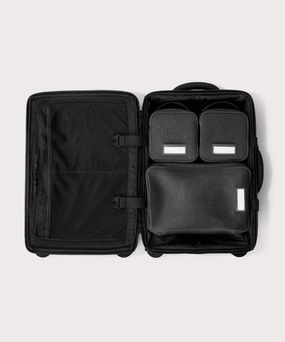 Top down of Seattle carry-on rolling luggage 20.5” in onyx with interior divider zipped and packing cubes packed into the right side.